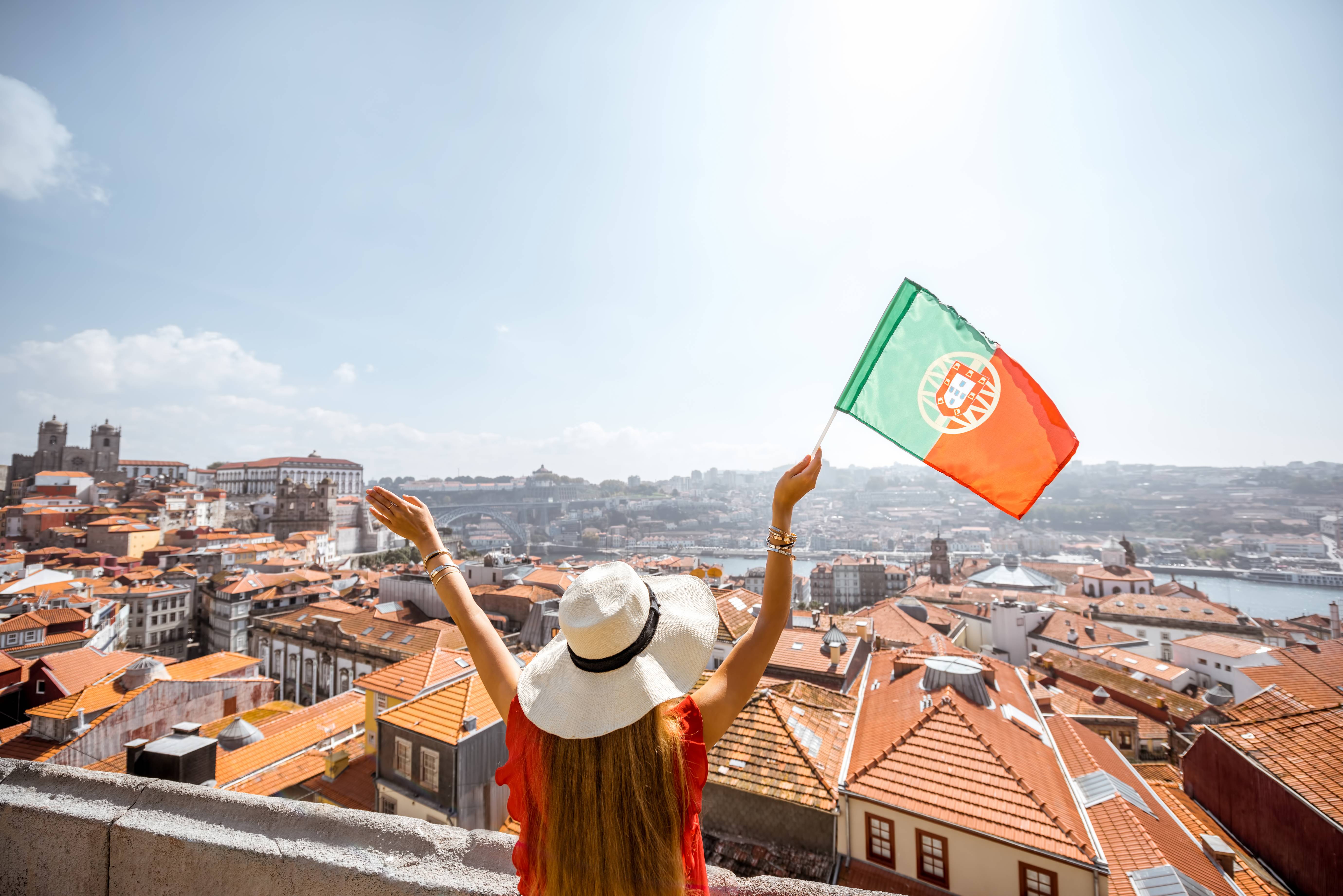 Porto riverside with woman holding Portuguese flag